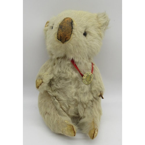 158 - Fully jointed rabbit fur koala bear with glass eyes, wearing a What A Day badge, sitting H22cm, and ... 