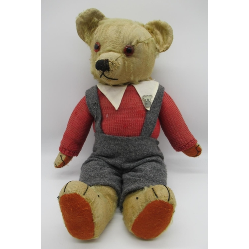 78 - Circa 1930s Merrythought teddy bear with glass eyes, jointed arms and legs and a swivel head wearing... 