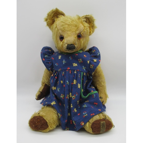 78 - Circa 1930s Merrythought teddy bear with glass eyes, jointed arms and legs and a swivel head wearing... 