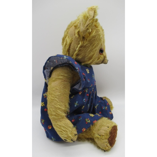 78 - Circa 1930s Merrythought teddy bear with glass eyes, jointed arms and legs and a swivel head wearing... 