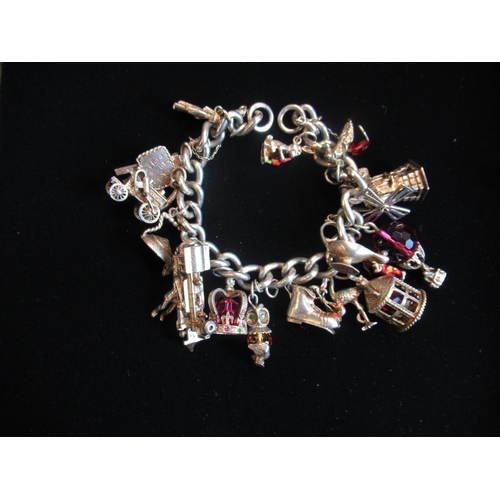 39 - Hallmarked Sterling silver charm bracelet with charms including locomotives, animals, building etc 3... 
