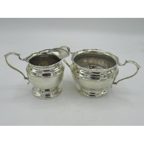 93 - Geo.V hallmarked silver sugar bowl and cream jug with scroll handles on circular foot, Birmingham 19... 