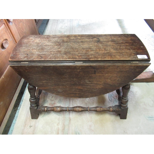 415 - Small Oak drop leaf occasional table on turned supports and under stretchers H47cm