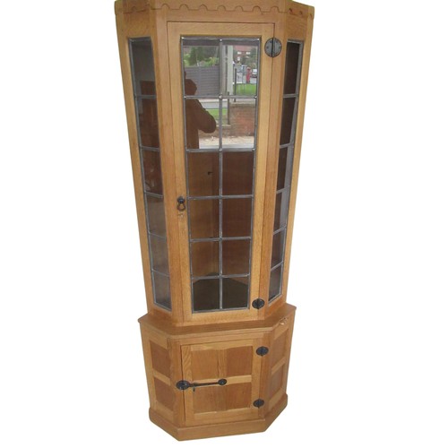 2010 - Robert Mouseman Thompson - oak corner cabinet with penny moulded cornice above lead glazed door and ... 