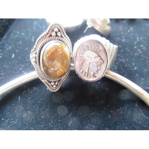 29 - Sterling silver ring with tiger eye stone to center Size O, another carved abalone in relief of a Gr... 