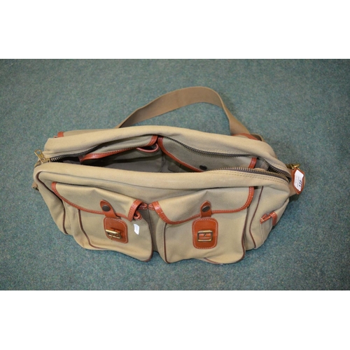 135 - Tan coloured canvas fly fishing bag with brown leather trim as new condition. Also includes stainles... 