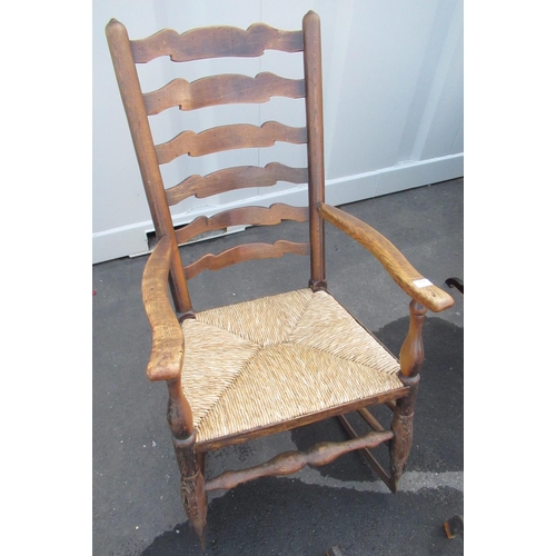 555 - Elm ladder back rush seated rocking armchair with forge made metal rockers