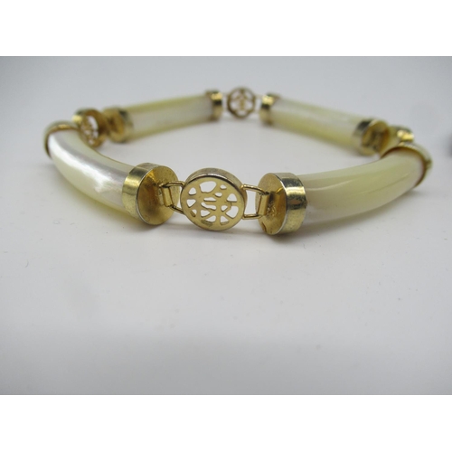 661 - Oriental silver gilt bracelet with elongated jade bars linked by roundels pierced with oriental symb... 