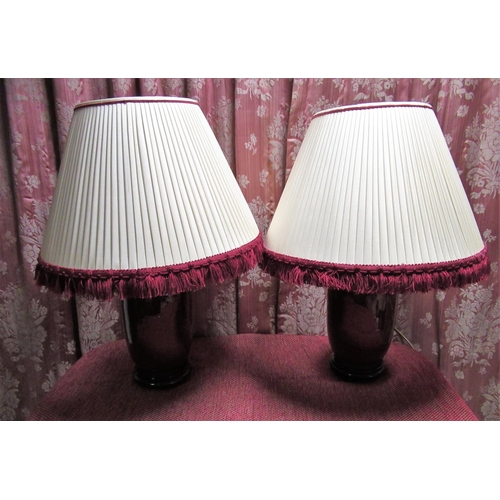 1013 - Pair of Sang de boeuf table lamps, the cylindrical tapering bodies with flared neck on hardwood base... 