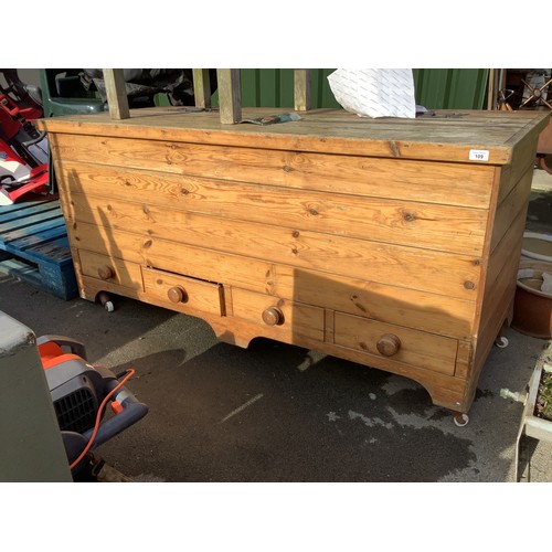 109 - Large pine chest on wheels, with hinged lid and four small drawers
