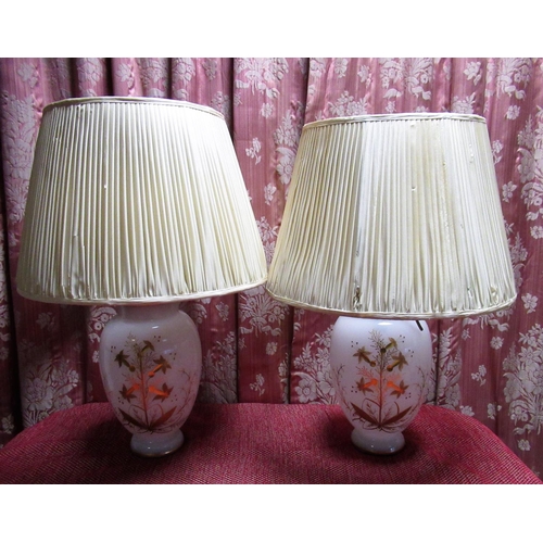 1220 - Pair of opaque glass table lamps, decorated in gilt with  trailing foliage, on circular bases with p... 