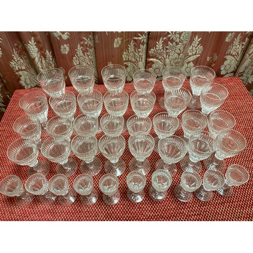 1507 - Part suite of drinking glasses with flute cut faceted trumpet shaped bowls, single knop stems and ci... 