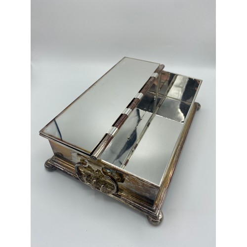1006 - Large silver plated Treasury style rectangular table  cigarette/cigar box, with two C scroll handles... 