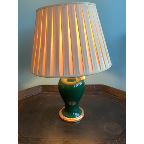 1226 - Pair of green glazed baluster shaped table lamps on gilt bases, pleated ivory shades, H57cm