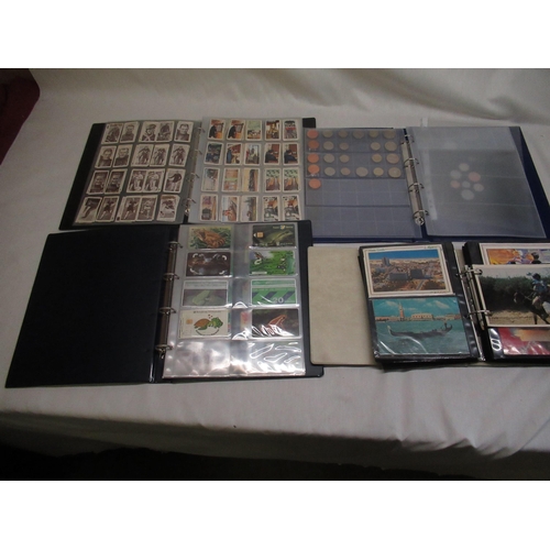 95 - Four albums of cigarette cards postcards coins etc