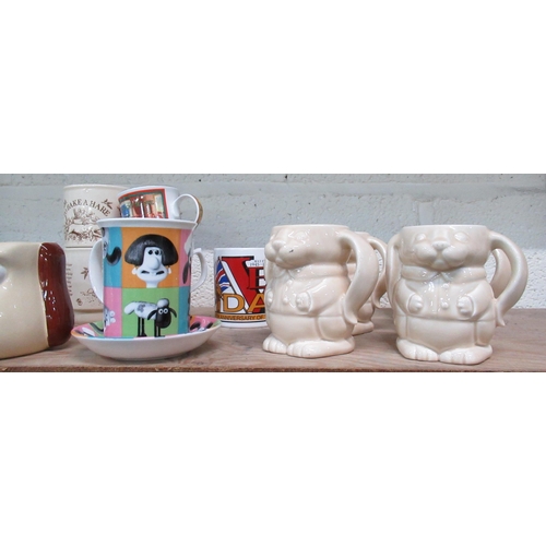 528 - Collection of various cups and mugs including Ringtons bunny mugs, Liquorish All Sorts mug, money bo... 