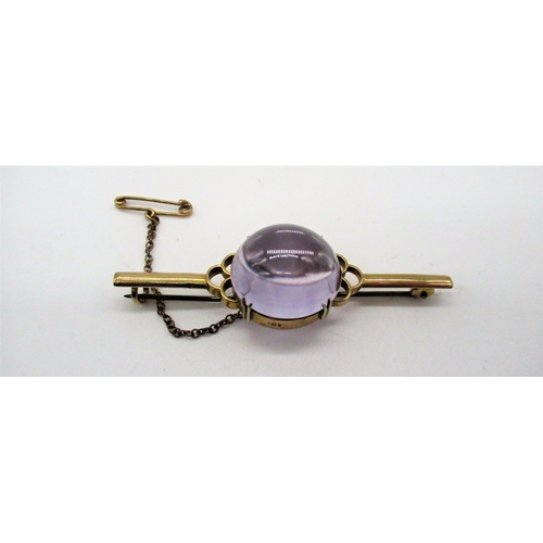 83 - 9ct yellow gold bar brooch with central polished lilac semi sphere stone, with safety chain, stamped... 