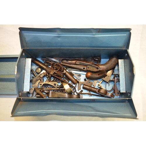 59 - Metal toolbox containing a quantity of various antique gun parts, including parts of a percussion ca... 