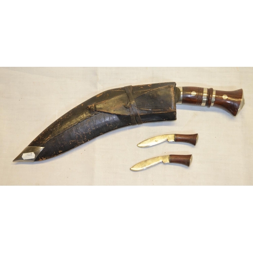 74 - Kukri in leather sheath with rosewood handles and two smaller knives (3)