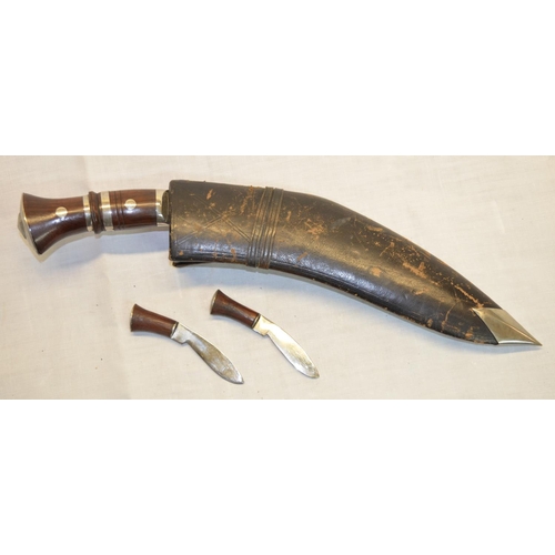 74 - Kukri in leather sheath with rosewood handles and two smaller knives (3)