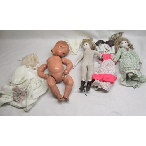 186 - Three various dolls and a collection of dolls clothing