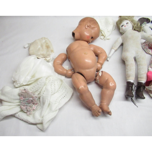 186 - Three various dolls and a collection of dolls clothing