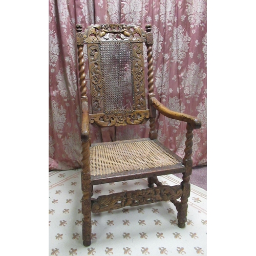 73 - Carolean style walnut elbow chair, with cane work seat, back and cherub cresting, the barley twist a... 