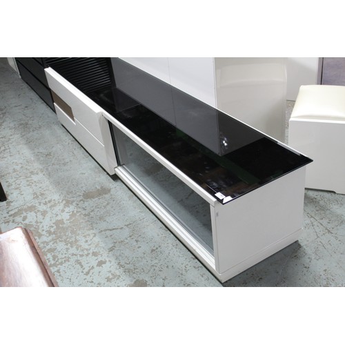 760 - Television cabinet with sliding cupboards concealing two drawers, glass sliding door with smoked gla... 