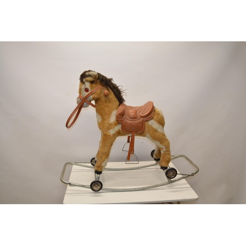 216 - Small child's fur lined rocking horse with plastic saddle, reins and hinged wheels, L90cm W40cm H74c... 