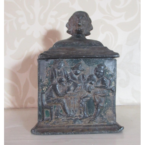 2101 - C19th lead square tobacco box, stepped cover with four faced mask head finial, the sides decorated i... 