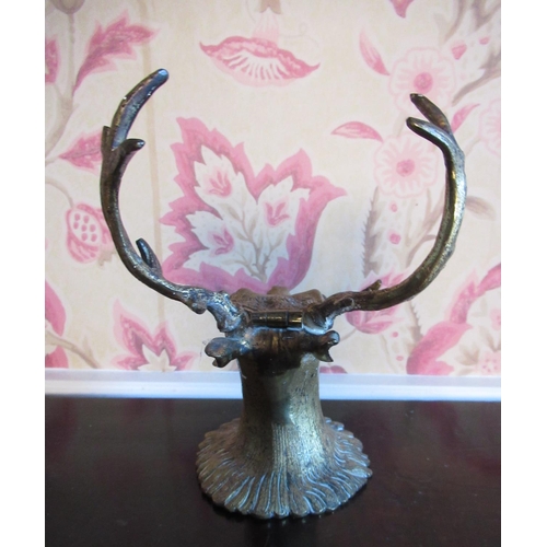 2036 - Edwardian brass ink stand in the form of a stags head, hinged with glass eyes, H15cm