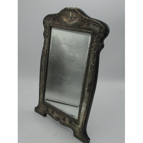 156 - Geo.V mirror with hallmarked Sterling silver repoussé decorated front and easel back (makers marks u... 