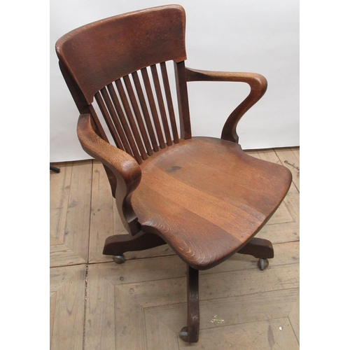 180 - Edwardian oak office swivel armchair, with curved back, square slats and shaped seat on Angus of Lon... 