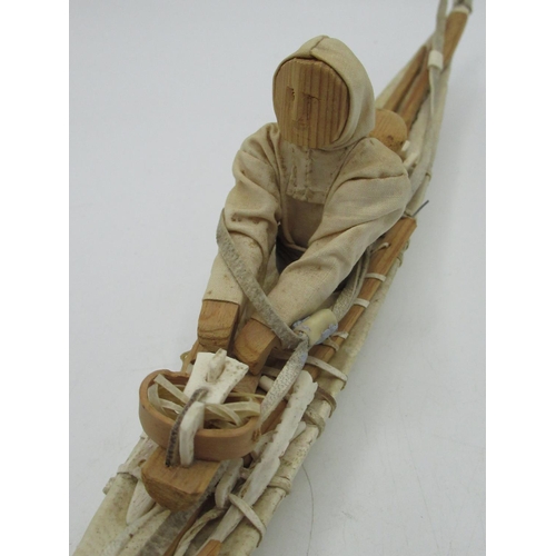 32 - Arctic region Inuit carved model of a fisherman in Umiak open skin canoe, L47cm