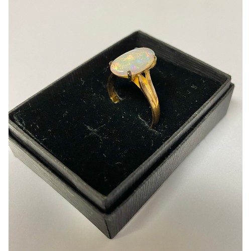 76 - 9ct yellow gold ring with oval claw set opal, stamped 375, size N with resizer, gross 2.5g