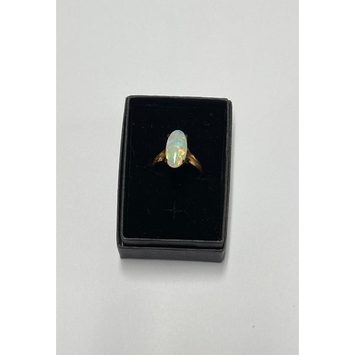 76 - 9ct yellow gold ring with oval claw set opal, stamped 375, size N with resizer, gross 2.5g