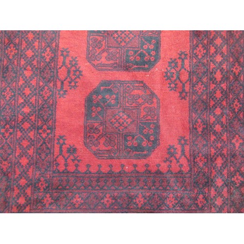 1461 - C20th traditional pattern wool rug, red ground with central field displaying four geometric pattern ... 