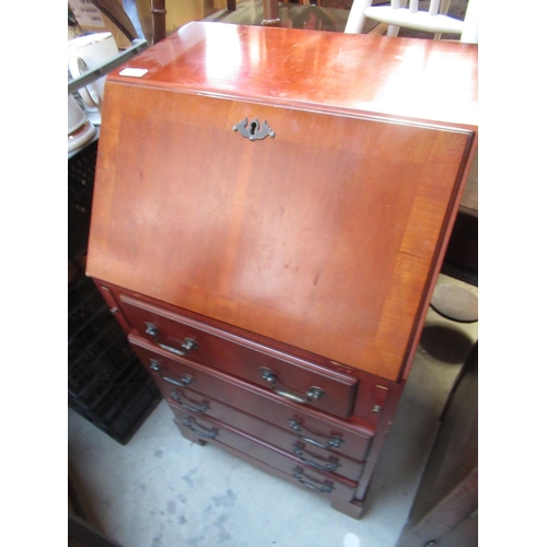 514 - Small modern mahogany bureau with fall front revealing fitted interior above four drawers on bracket... 