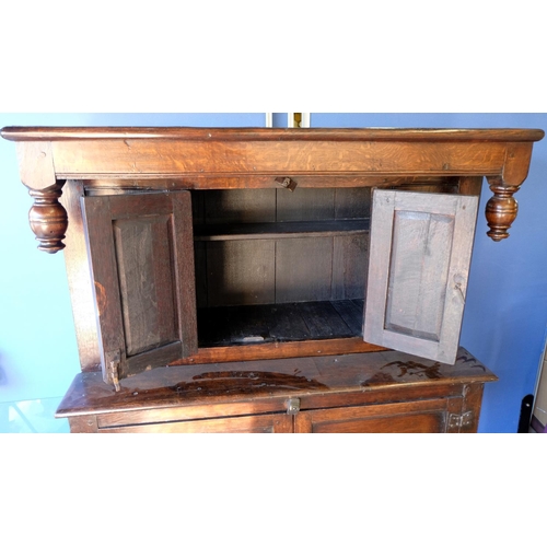 1527 - C18th and later oak court type cupboard, top with turned pendant finials and two panelled doors, bas... 