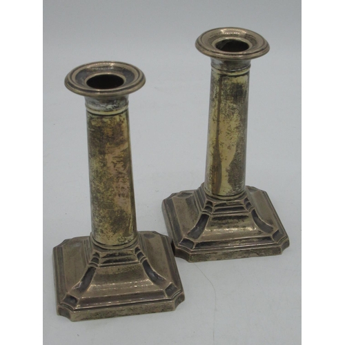 1149 - Pair of Geo.V hallmarked Sterling silver dressing table candlesticks with plain column on stepped an... 