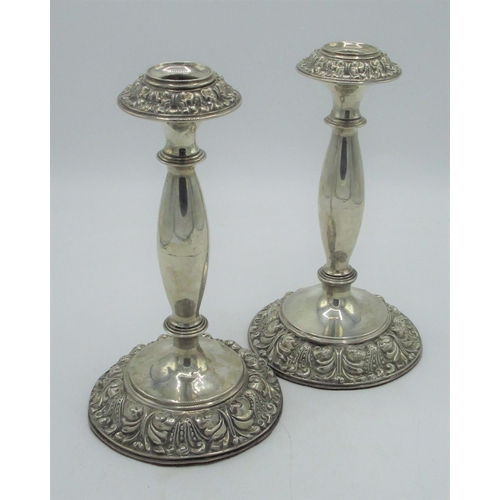 1152 - Pair of Edw.VII candlesticks, shaped columns on circular bases with repoussé detail, by Jones & Crom... 