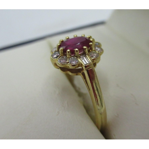 1130 - Hallmarked 18ct yellow gold diamond and ruby cluster ring with central oval cut ruby, ten round cut ... 