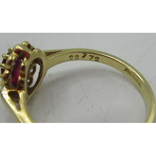 1130 - Hallmarked 18ct yellow gold diamond and ruby cluster ring with central oval cut ruby, ten round cut ... 