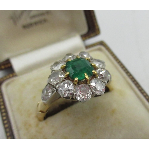 1128 - Diamond and emerald cluster ring with central cushion cut emerald, a halo of ten round cut diamonds ... 