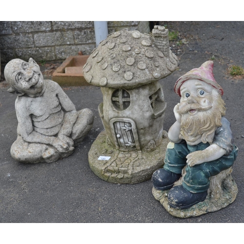 149 - Garden ornament in shape of fairy house with plastic gnome and reconstitute stone pixie