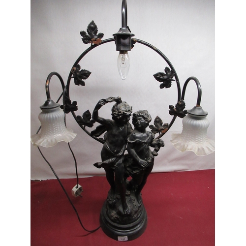 157 - Cast metal figural three light table lamp of two cherubic figures on ebonized base, indistinctly sig... 