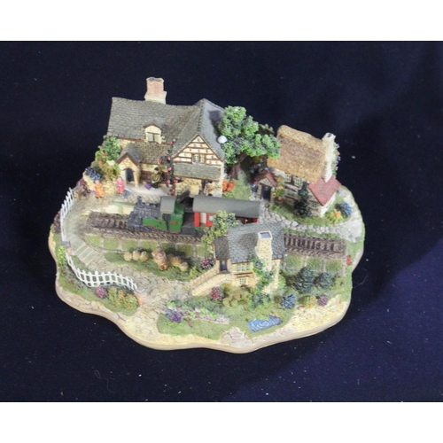 348 - Boxed Lilliput Lane model train passing through a village with locals