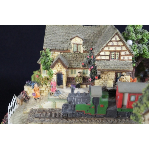 348 - Boxed Lilliput Lane model train passing through a village with locals