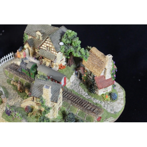 348 - Boxed Lilliput Lane model train passing through a village with locals