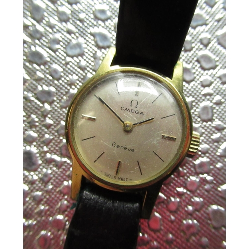 86 - Ladies Omega Geneve wristwatch, gold plated case on black leather strap with snap on stainless steel... 